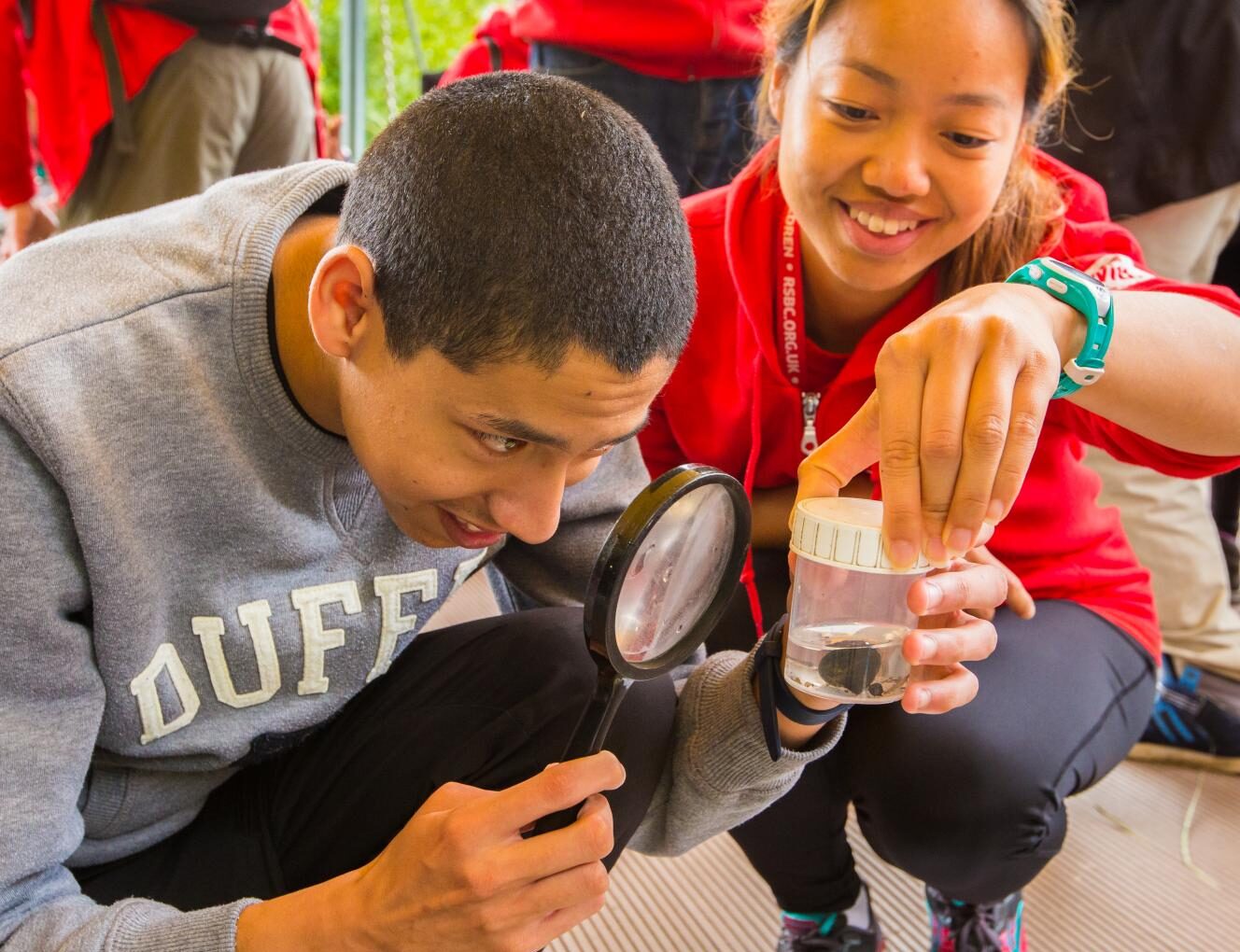Students look through a magnifying glass