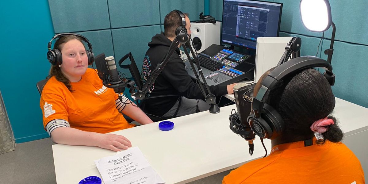 Three people recording a podcast in a media room