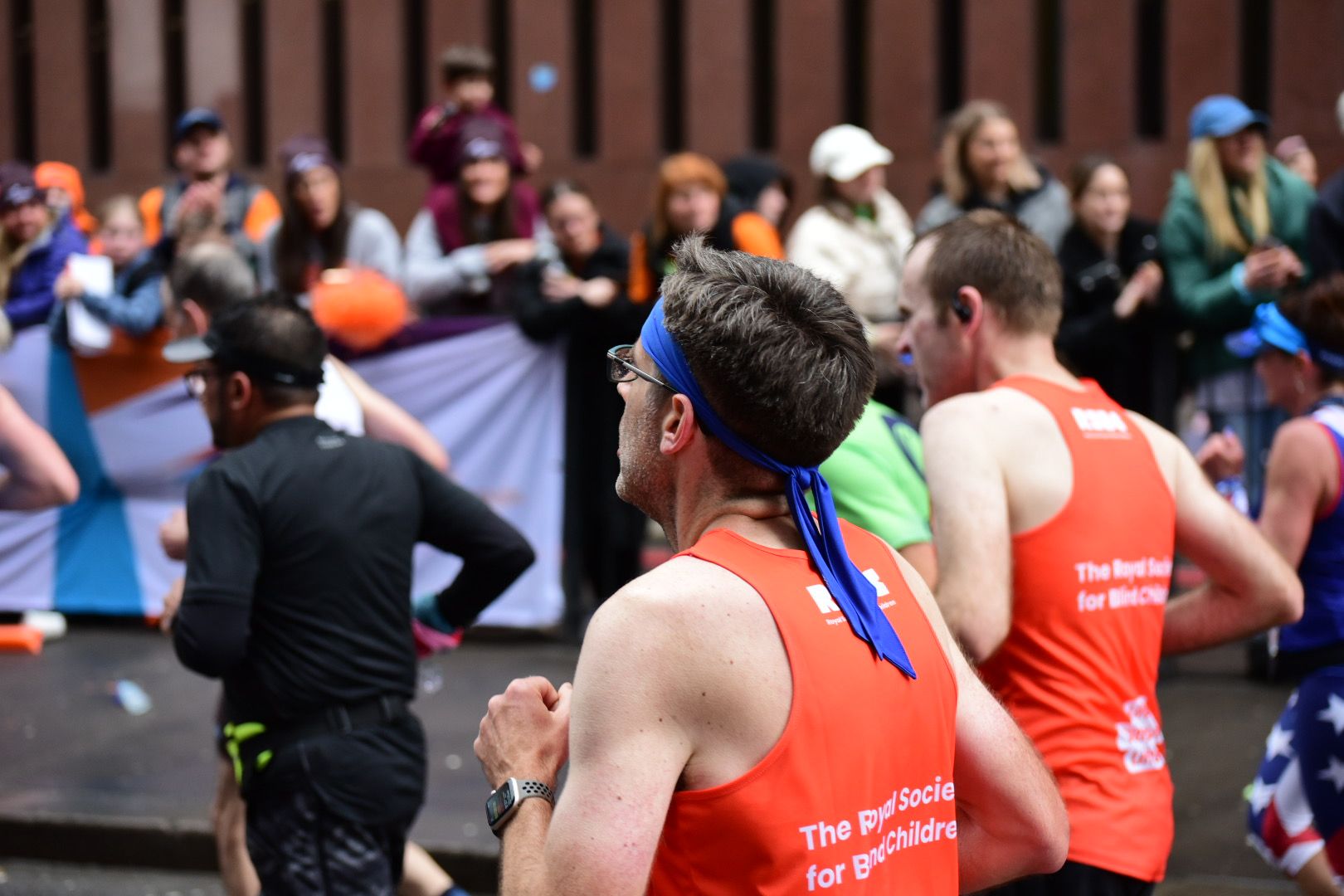 2 men running with the RSBC orange vest
