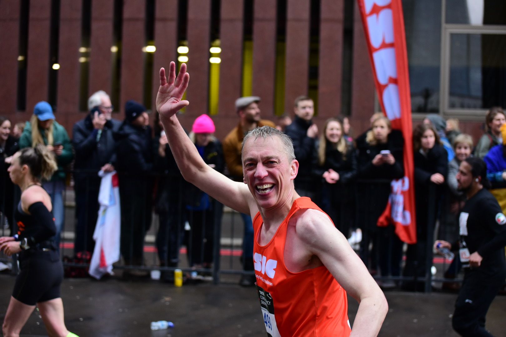 RSBC runner in an orange vest going past RSBC Cheer Point at Mile 23.