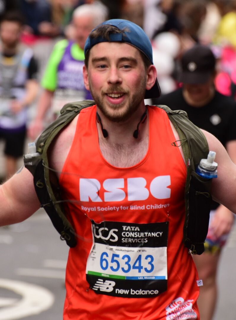 An RSBC London Marathon runner facing the camera and showing off his Team RSBC running vest.